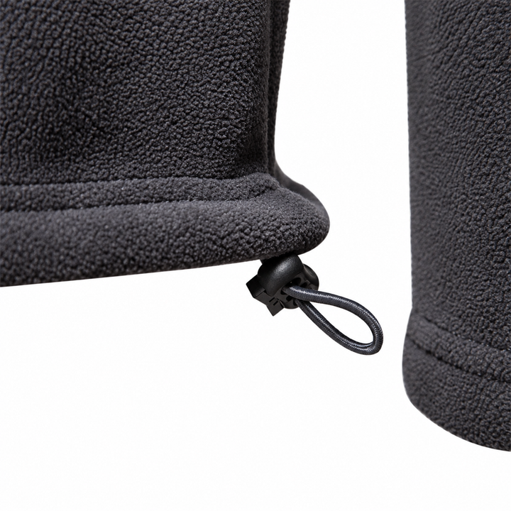 Detail of the drawcord and toggle at the hem of the charcoal fleece