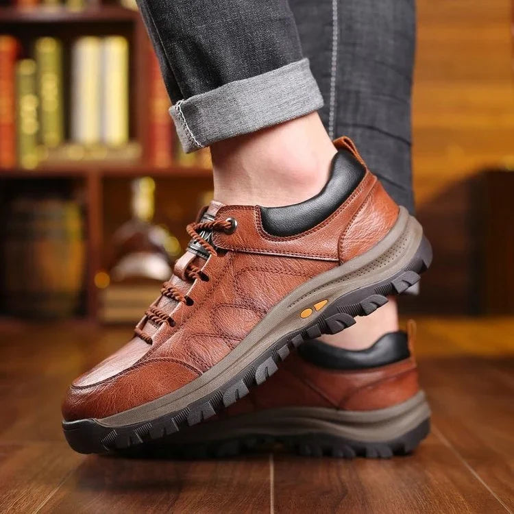 Brown trail walking shoes worn in motion with rolled jeans