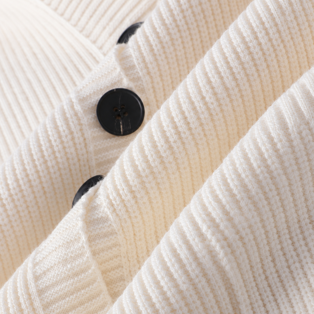 Detail of the black buttons and ribbed texture on the ivory cardigan