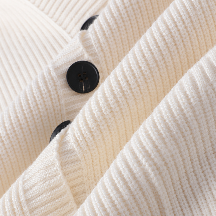 Detail of the black buttons and ribbed texture on the ivory cardigan