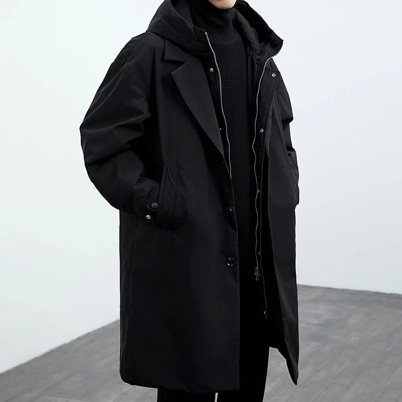 Black hooded trench coat with notch lapel worn over a dark turtleneck