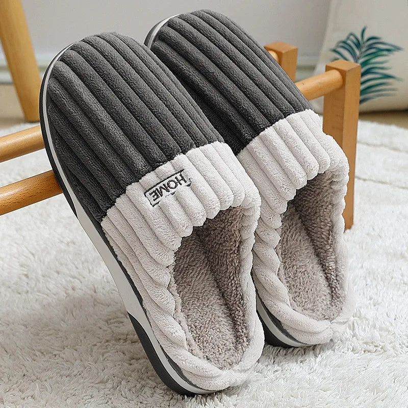 Charcoal ribbed slippers with cream cuff leaning on a white rug