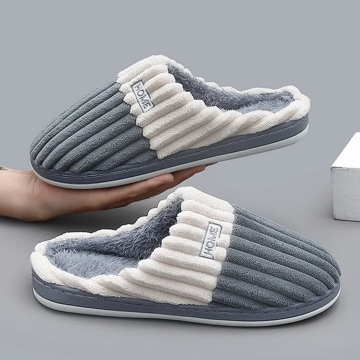 Slate gray ribbed slippers shown with a hand holding the pair