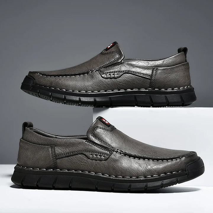 Pair of gray slip on loafers with stitched detail and black sole