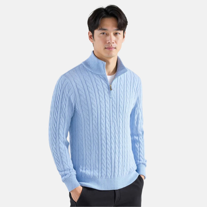 Man wearing a light blue cable knit quarter zip pullover, front view