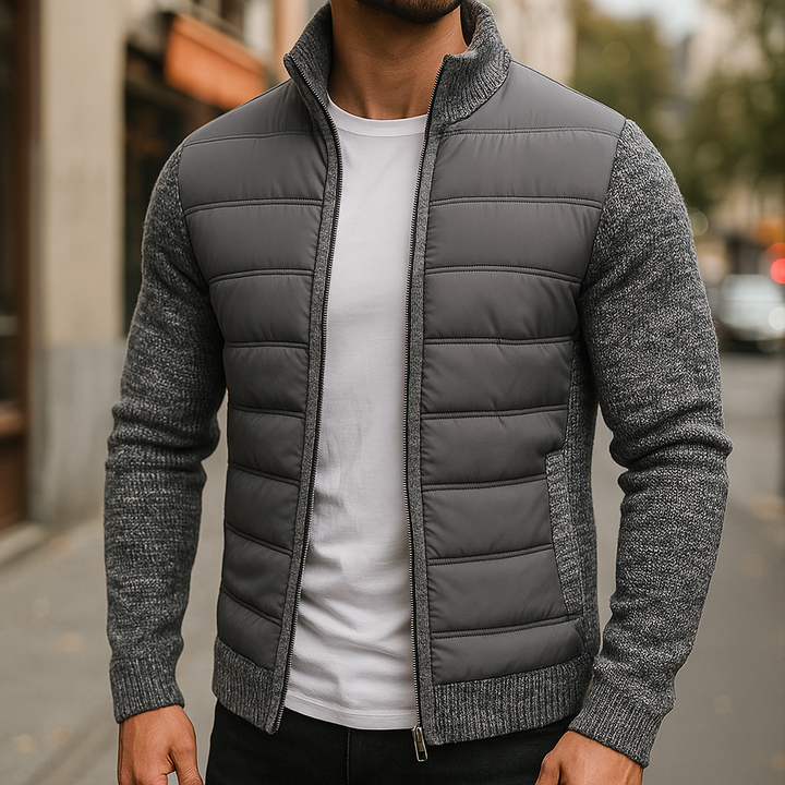 Man wearing the dark gray quilted zip up jacket with knit sleeves, front view