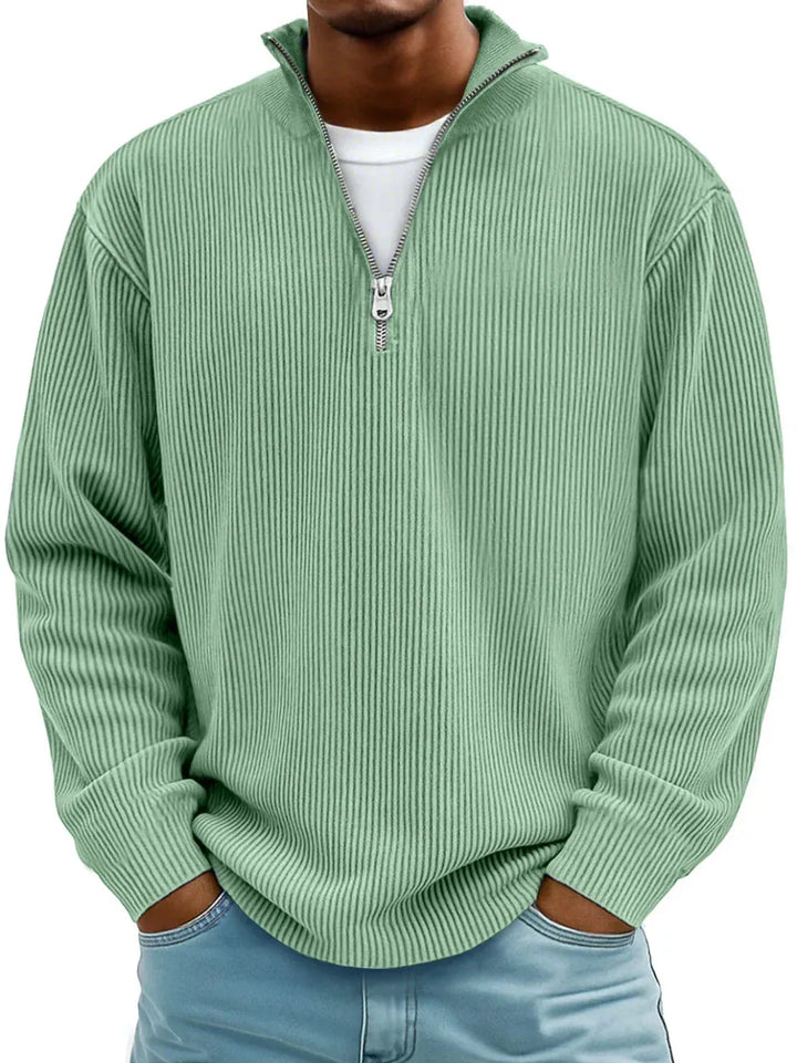 Ribbed Sage Green quarter zip sweater, model with hands in jeans pockets