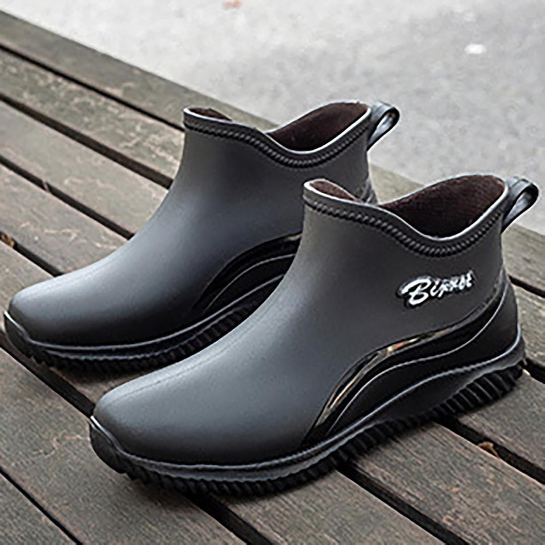 Black slip on ankle boots on a wooden bench, grip sole visible
