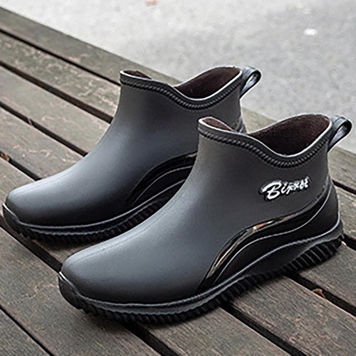 Black slip on ankle boots on a wooden bench, grip sole visible