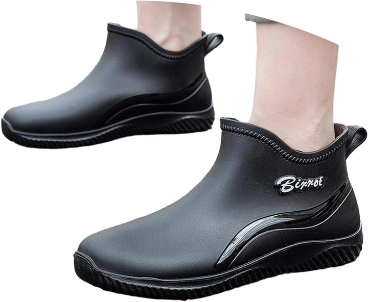 Pair of black short rain boots with one worn on foot