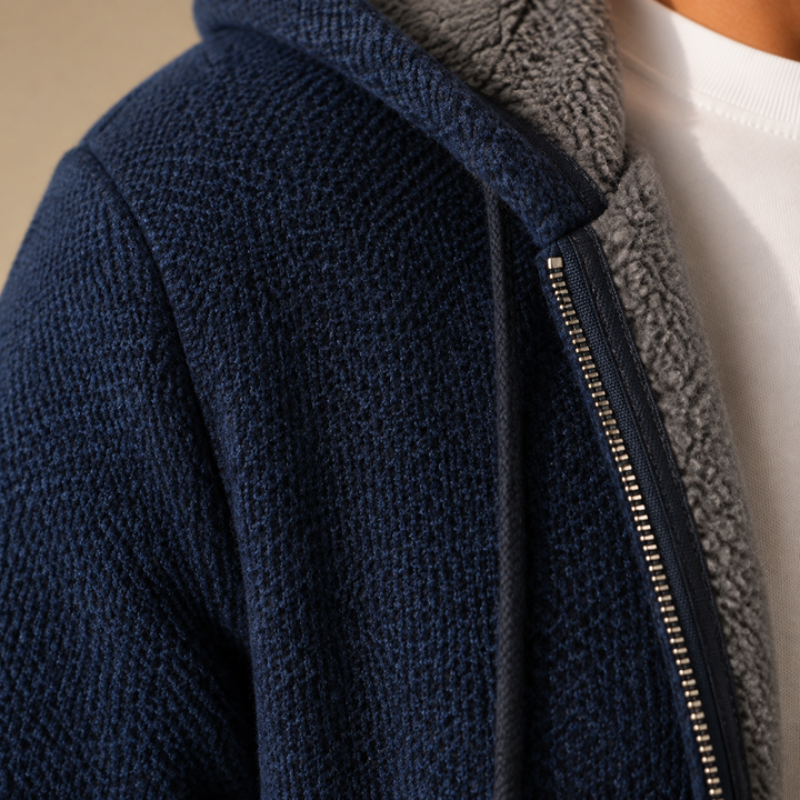 Close-up of the navy knit look fabric, zipper and gray sherpa collar