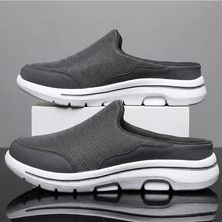 Gray backless mesh sneakers on a display block