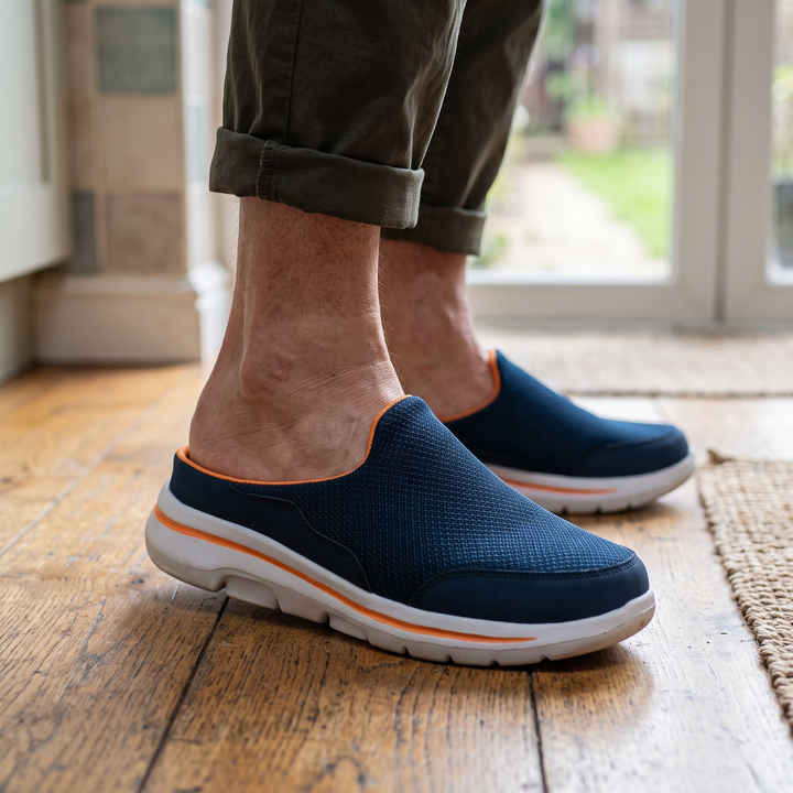 Navy backless mesh sneakers worn with rolled olive pants on a wooden floor