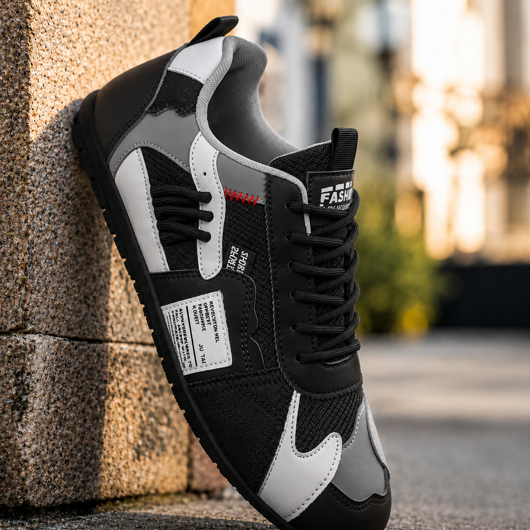 Black color block sneaker with white accents, side view against a stone wall