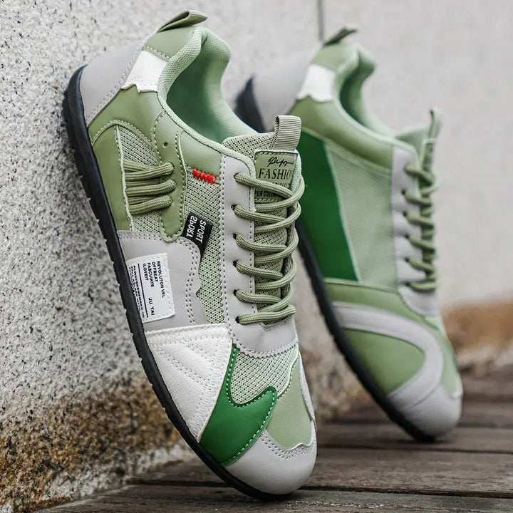 Green lace-up low tops with mesh panels leaning on a wall