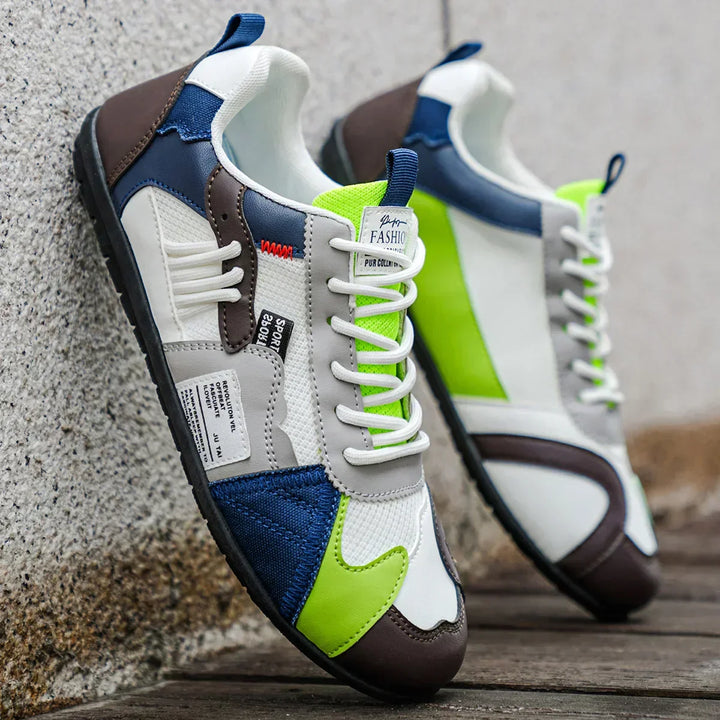 White low top sneakers with blue and lime panels, angled side view