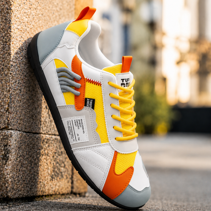 Yellow retro low top sneaker with orange details, angled outdoor view