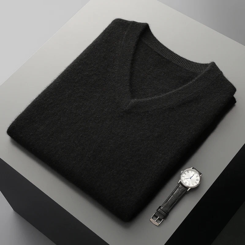 Black V-neck knit vest folded flat on a gray surface
