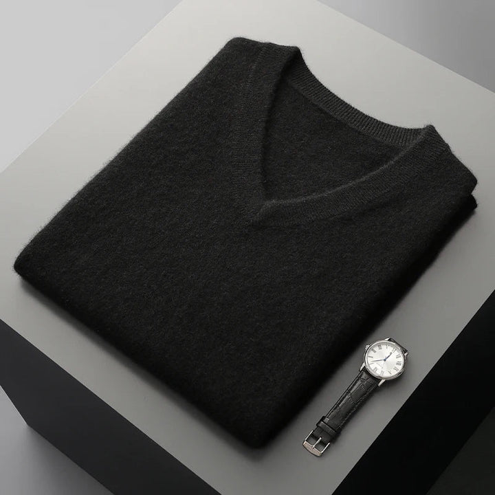 Black V-neck knit vest folded flat on a gray surface