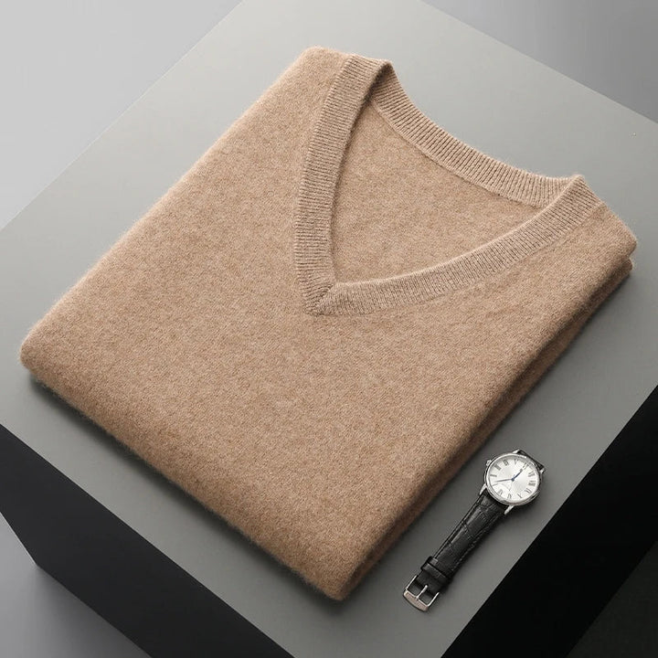 Camel V-neck sweater vest folded flat next to a wristwatch
