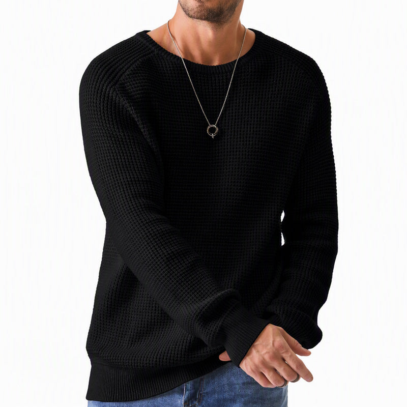 Man wearing a black waffle knit crewneck raglan sweater