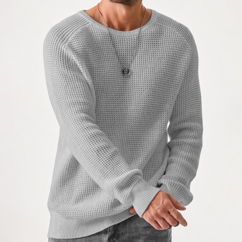 Man wearing a light gray waffle knit crewneck raglan sweater