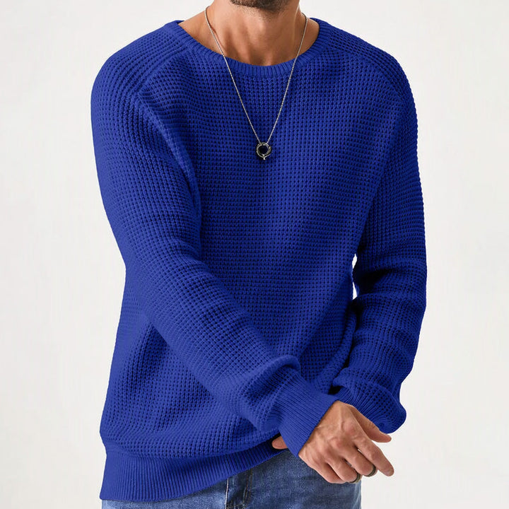 Man wearing a royal blue waffle knit crewneck raglan sweater