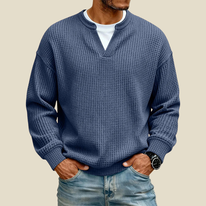 Blue waffle knit sweater worn with hands in pockets