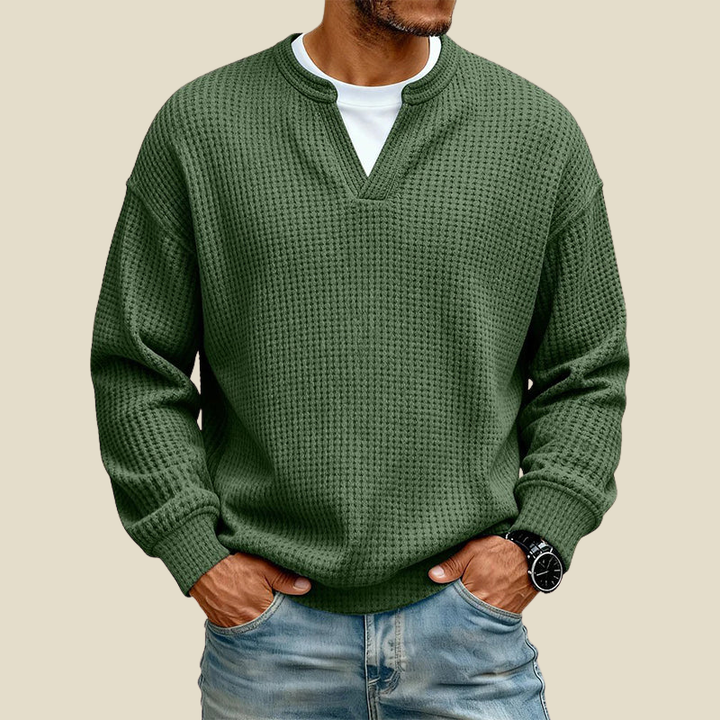 Green relaxed pullover showing dropped shoulders and ribbed cuffs