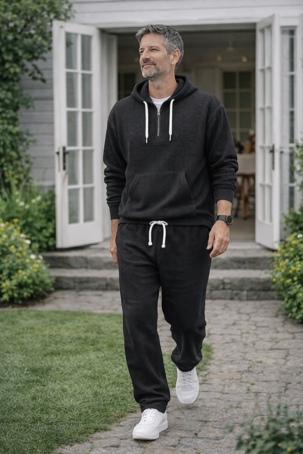 Men's tracksuit in black, waffle knit half zip hoodie and jogger set worn outdoors