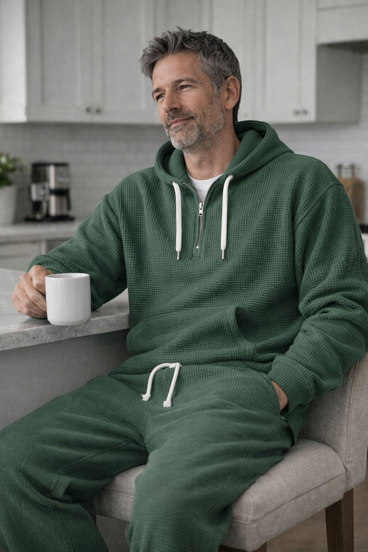 Green half zip hoodie and joggers worn seated with a coffee mug