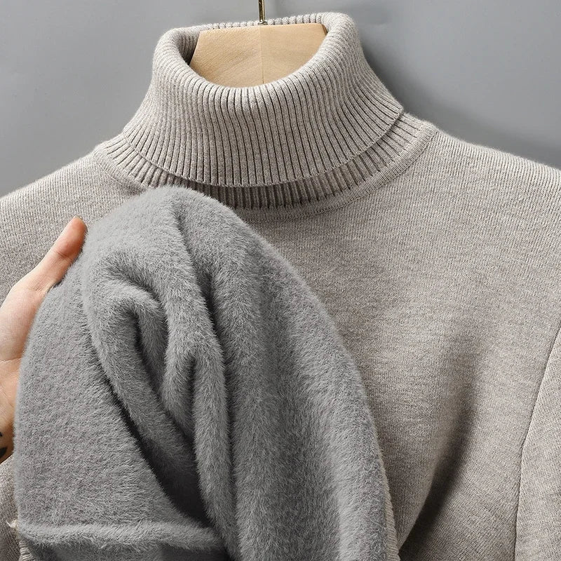 Gray turtleneck pullover on a hanger with the fleece lining visible at the sleeve