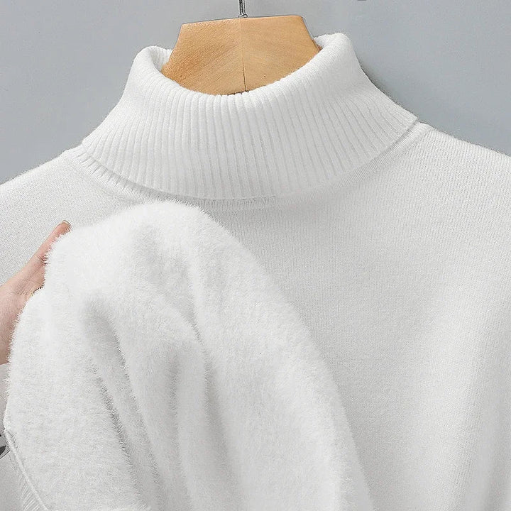 White turtleneck pullover on a hanger with the fleece lining visible at the sleeve