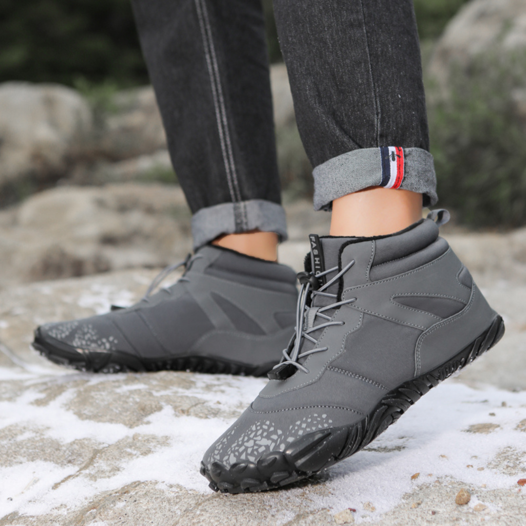 Gray ankle boots worn on rocks with cuffed jeans, front three quarter view