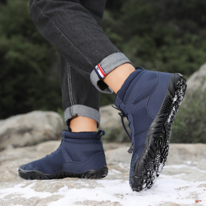Navy ankle boots worn outdoors with cuffed jeans, one foot lifted mid step