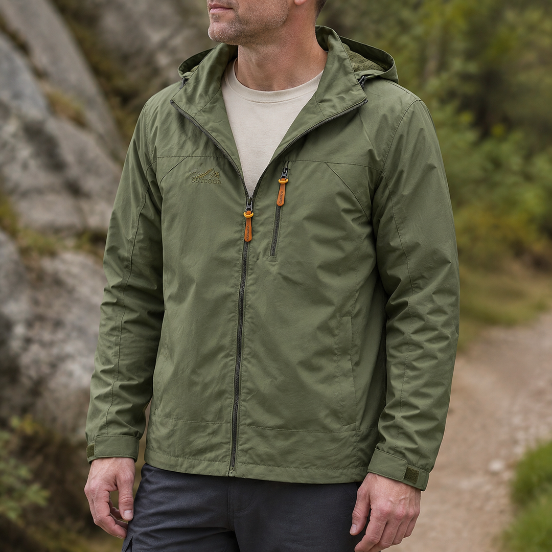 Olive hooded windbreaker jacket worn over a beige tee on a rocky trail