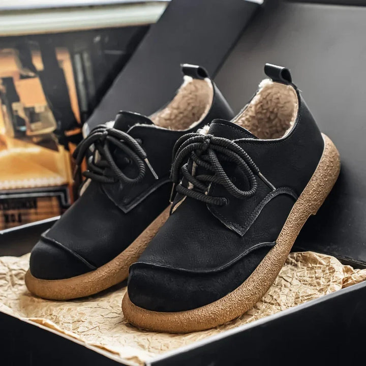 Pair of black fleece lined lace up shoes on a display box