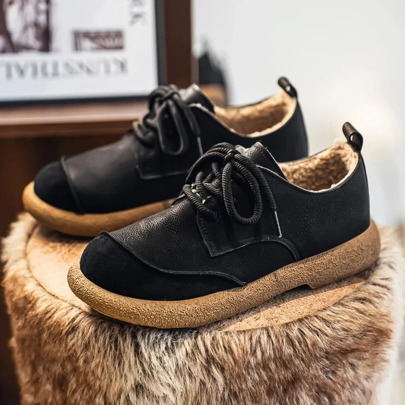 Black fleece lined lace up shoes styled on a fluffy stool