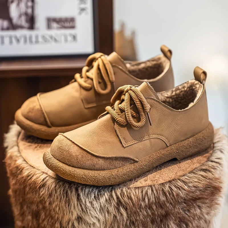 Tan fleece lined lace up shoes styled on a fluffy stool