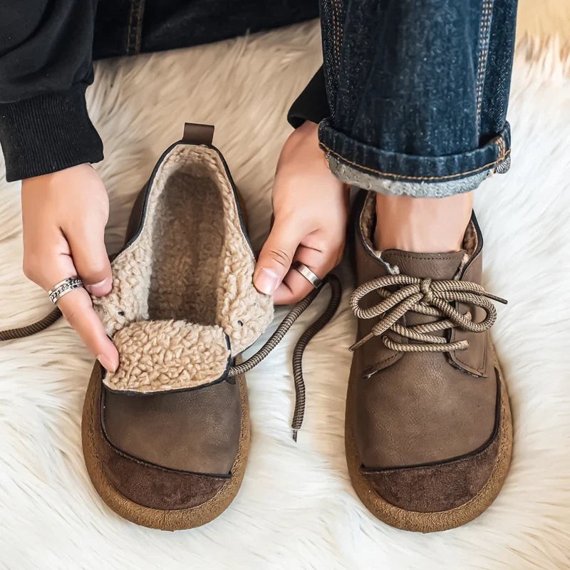 Hands holding a taupe lace up shoe open to show the fleece lining next to a worn shoe