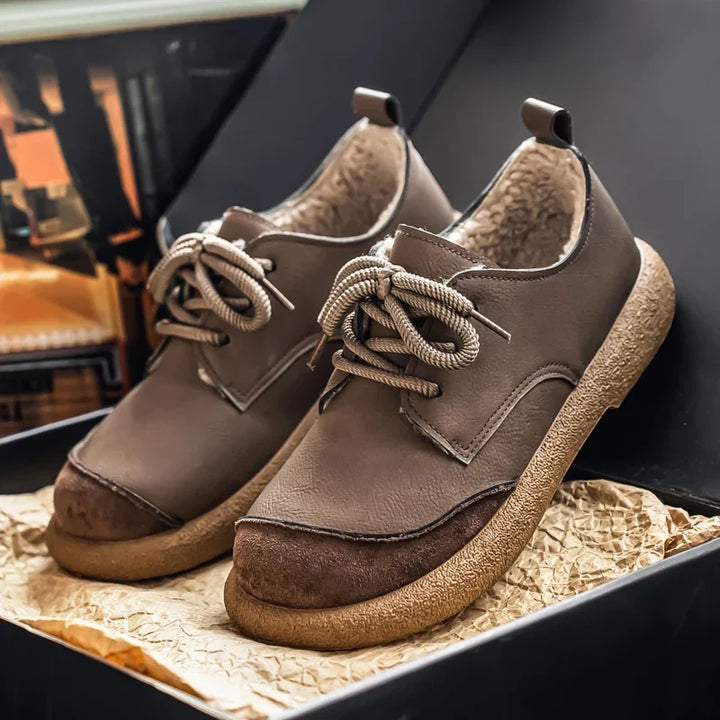 Pair of taupe fleece lined lace up shoes on a display box