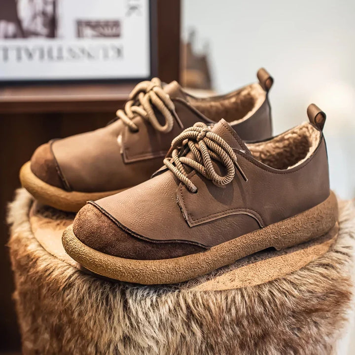 Taupe fleece lined lace up shoes styled on a fluffy stool