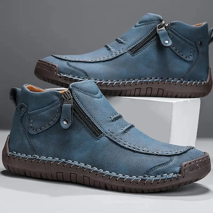 Pair of blue side zip ankle boots with stitched toe and dark sole