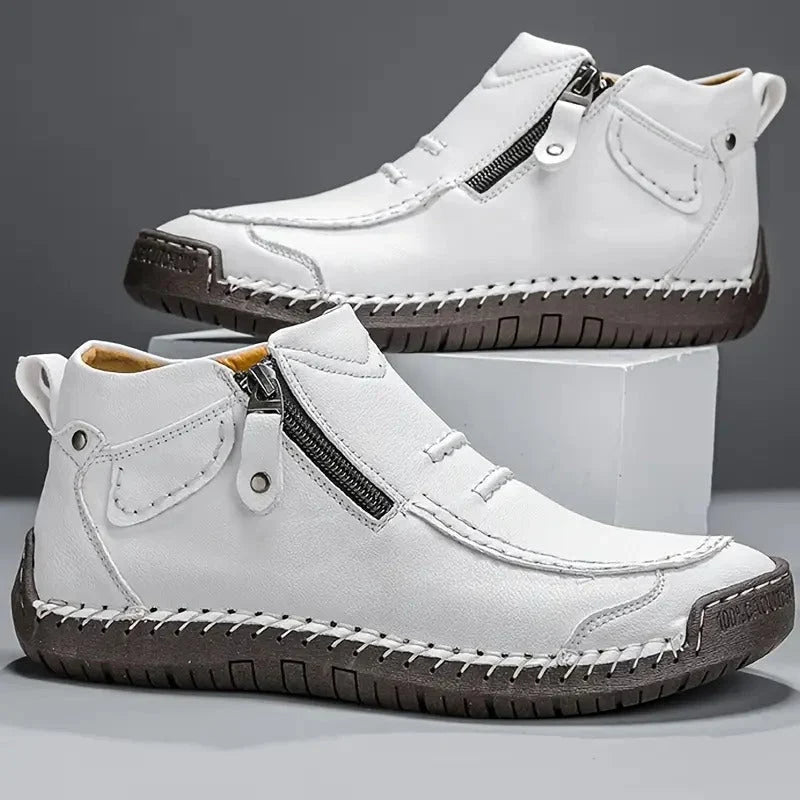 Pair of white side zip ankle boots with contrast stitching and dark sole