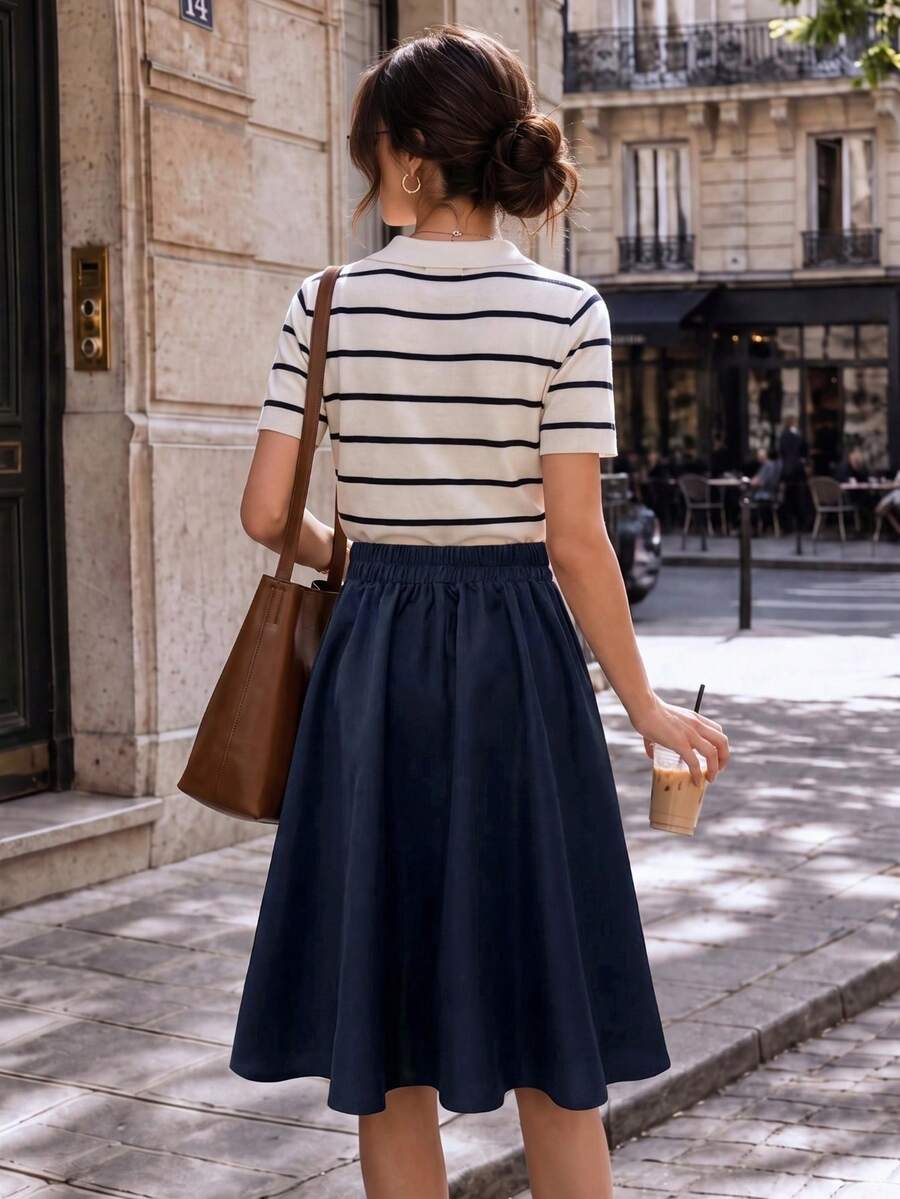 Back view of the navy a line skirt with a striped top on a sunny street