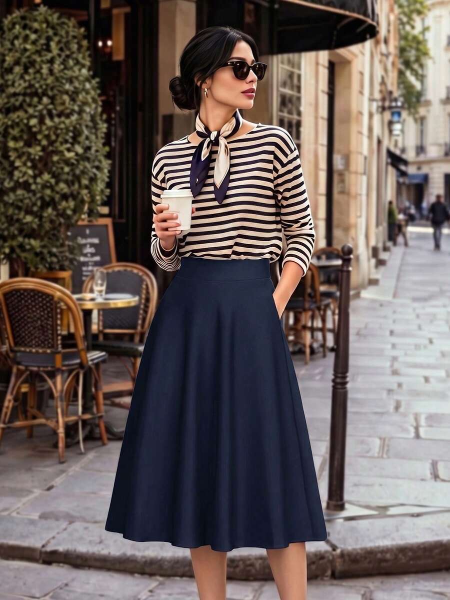 Navy high waist skirt worn with a striped sweater and scarf at a cafe