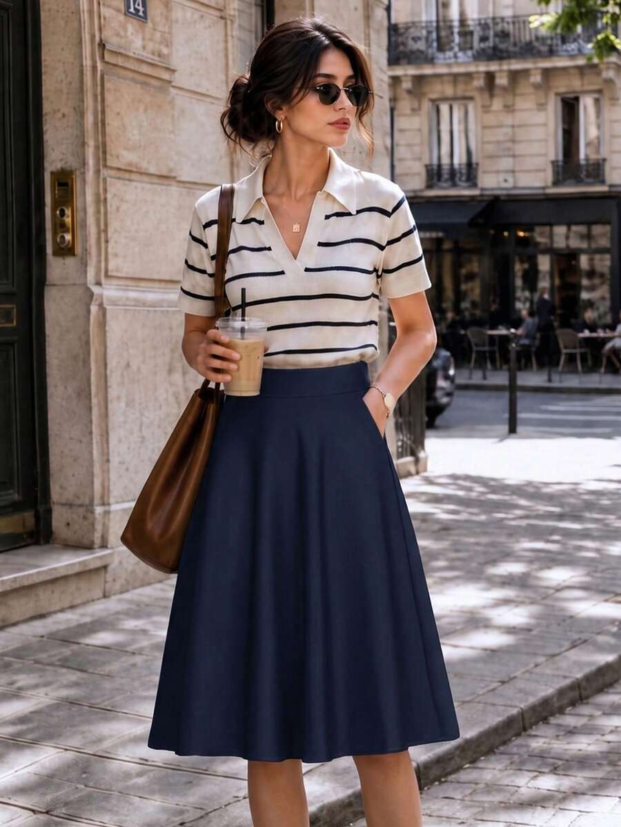 Navy midi skirt styled with a striped top and brown bag on a city street
