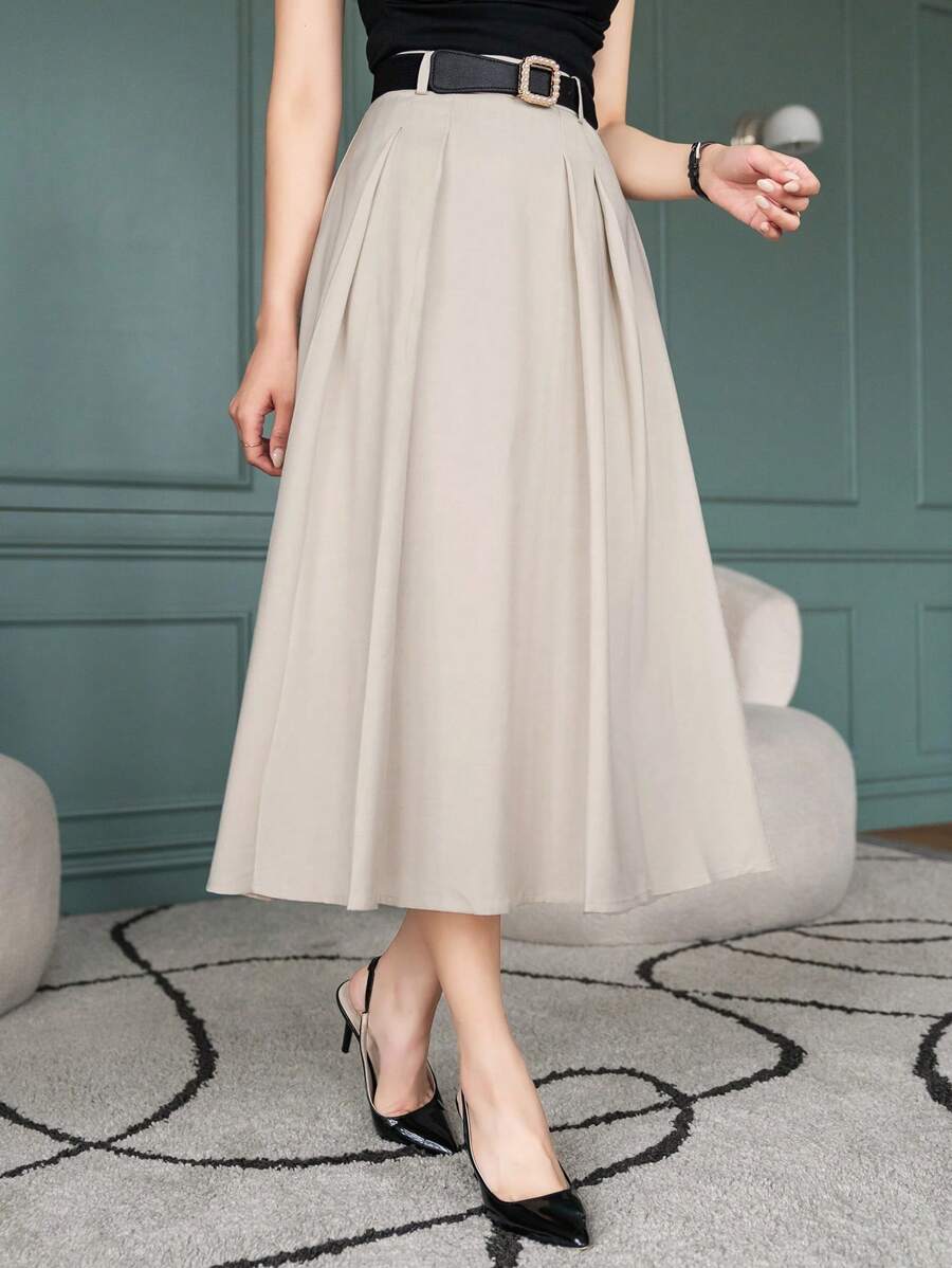 Women's A line skirt in beige, pleated midi with belt, worn with black top and heels