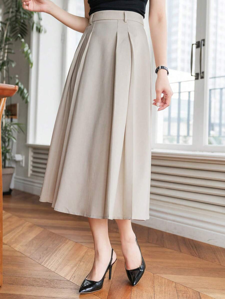 Side view of the beige A line midi skirt with folded pleats