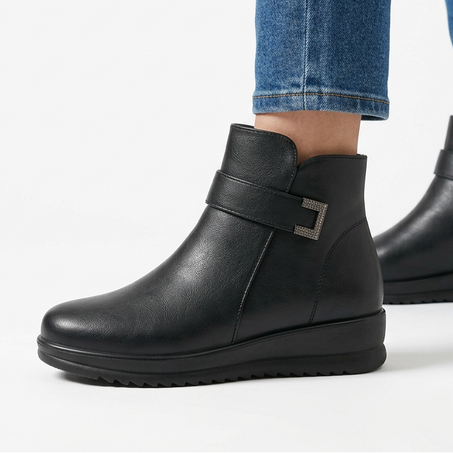 Side view of the black wedge ankle boot with buckle strap and ridged sole